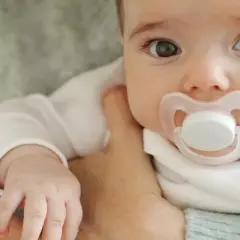 Malutkie dziecko z wielkimi oczami i smoczkiem w buzi. Czas pomyśleć, jak odzwyczaić dziecko od smoczka, by mogło swobodnie odkrywać świat.