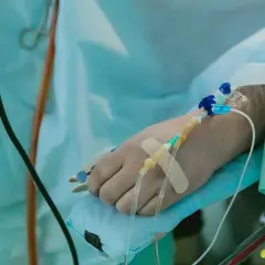 Ręka pacjenta z wenflonem i plastrem, przygotowana do podawania płynów po operacji.