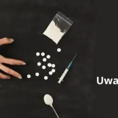 Dwie ręce się szarpią, obok biały proszek, tabletki, strzykawka i łyżeczka. Uważaj na fentanyl.