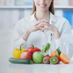 Dietetyk z uśmiechem prezentuje świeże warzywa i owoce. Dowiedz się, czy po gastroskopii można jeść zdrowo i bezpiecznie.