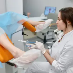 Lekarka przygotowuje pacjentkę do zabiegu jednodniowego. Pomyśl, co zabrać do szpitala na zabieg jednodniowy, by czuć się komfortowo.