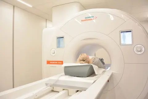 Pacjentka leży w aparacie do rezonansu magnetycznego. Badanie to nie wykorzystuje promieniowania jonizującego.