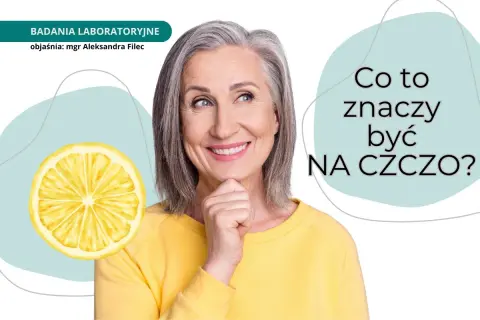 Uśmiechnięta kobieta zastanawia się, co to znaczy być na czczo. Obok cytryna i napis "BADANIA LABORATORYJNE".
